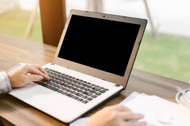 Arka plan gibi kahve dükkanında boş siyah ekran, akıllı telefon ve belge ile Laptop ile çalışan işadamı yakın çekim.