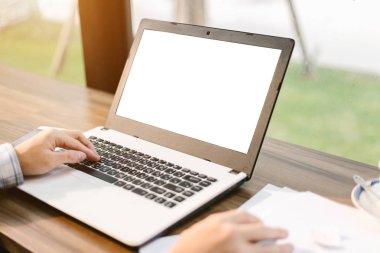 Arka plan gibi kahve dükkanında boş beyaz ekran, akıllı telefon ve belge ile Laptop ile çalışan işadamı yakın çekim.