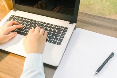 Dizüstü bilgisayar ile çalışan iş kadın yakın çekim arka plan gibi kahve dükkanında bir not belgesi ve akıllı telefon yapmak.