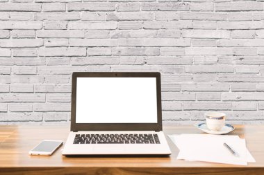 Boş beyaz ekran ile dizüstü mockup görüntü, akıllı telefon, kahve duvarı büyük doku arka plan ahşap masa üzerinde kahve bardağı.