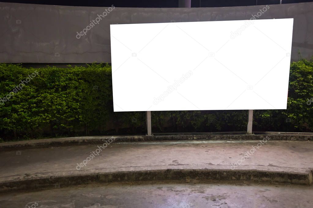 White blank billboard ready for new advertisement,lightbox mounted on the wall of store street in a city at night.