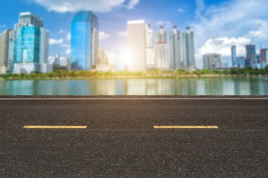 Şehir arka plan silüeti üzerinde işaretleme hatları beyaz çizgili doku ve Cityscape ile asfalt yol.