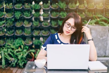 iş Asyalı kadın dizüstü bilgisayar ve saat ile çalışan o