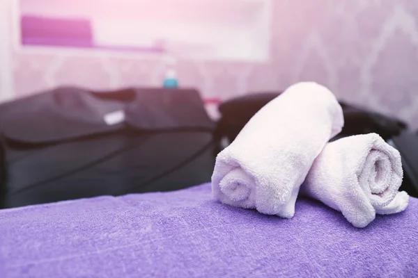 Turquoise spa towels pile on armchairs with washing stands in ha