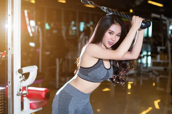 フィットネススポーツジムでローイングマシン シートケーブルロウマシン でトレーニングを行うアジアの女性スポーツ運動機器とフィットネスヘルスクラブジムの背景 — ストック写真