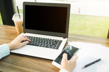 Akıllı telefon la çalışan İş kadınının yakın çekim, b ile dizüstü bilgisayar