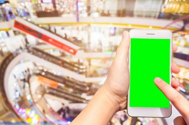 kadın kullanımı cep telefonları bulanık görüntüler alışveriş merkezi arka plan.