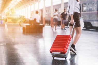 Arabası kırmızı çantasını taşıyan genç kadın yolcunun yakın çekim