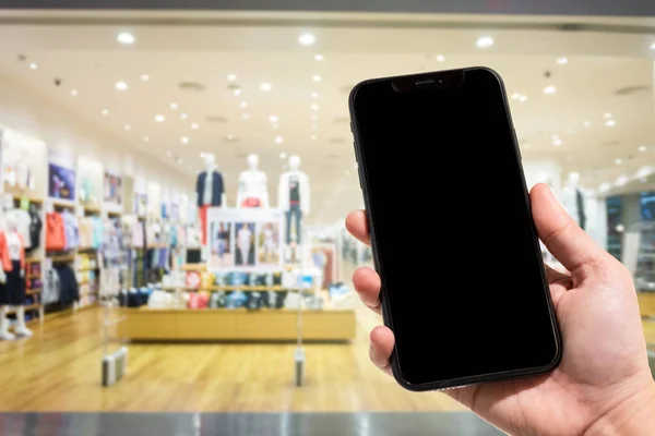 Primer plano de las imágenes borrosas del teléfono inteligente de uso femenino en el centro comercial y — Foto de Stock