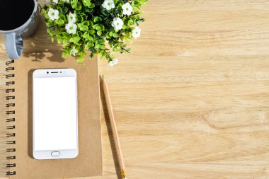 Defterde akıllı telefon, saksı ağacı, kalem ve kahve fincanı...