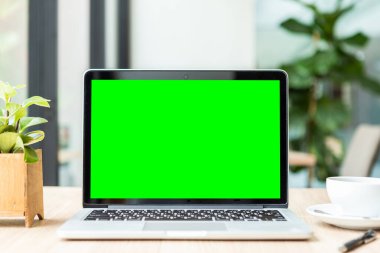 Boş ekranlı dizüstü bilgisayarın modeli ve kahve fincanı.