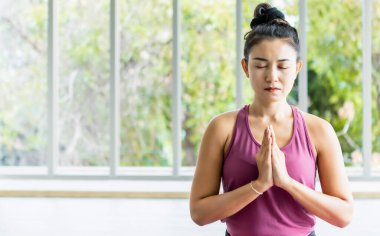 Asyalı kadınlar yoga antrenmanı yapıyorlar pembe kıyafetler giyip meditasyon yapıyorlar sağlık yaşam tarzı ve sağlık konsepti üzerinde spor salonunda çalışıyorlar.