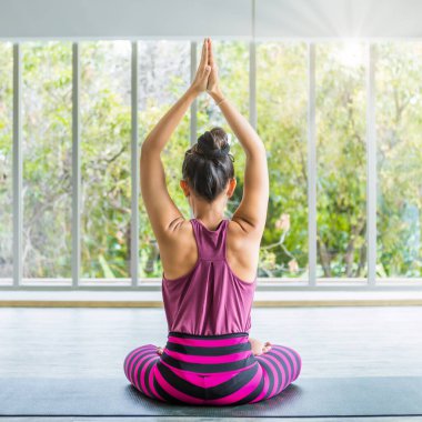 Asyalı kadınlar yoga antrenmanı yapıyorlar pembe kıyafetler giyip meditasyon yapıyorlar sağlık yaşam tarzı ve sağlık konsepti üzerinde spor salonunda çalışıyorlar.