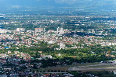 CHIANG MAI, THAILAND - 9 Haziran 2020: Beyaz bulutlu parlak mavi gökyüzü arkaplanı üzerinde şehir manzarası olan dağları görmek. Chiang Mai, Tayland 'ın