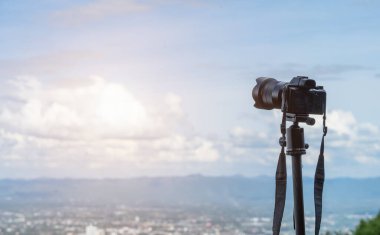 Aynasız kamera, şehrin manzarası dağ sırasına hayran kalıyor. Şehir atmosferi üzerinde parlak mavi gökyüzü arkaplanı, Tripod 'ta aynası yok..