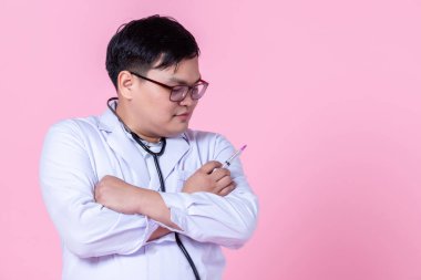 Asyalı doktor terapi uzmanı, steteskop pozitif duygularla tavsiye veriyor kollarını kavuşturup yan gözüne şırınga tutarak pembe boş fotokopi alanındaki kameraya bakıyor.