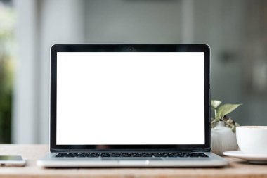 Kahve dükkanının arka planında boş ekranlı ve akıllı telefonlu dizüstü bilgisayarın kopyası, beyaz ekran.