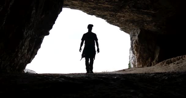 男性徒步旅行者爬出洞穴远足户外男子远足轮廓. — 图库视频影像