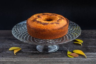 Lezzetli, yumuşak ve güzel krema ve çikolatayla karıştırılmış bir pasta. Ailenin kahvaltısı ya da öğlen atıştırması için yapılmış. Koyu bir arka planda, uzun, cam bir tabakta servis edilir..