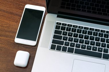 Bilgisayarın siyah ekranına bakmak, evde çalışmak için bir cihaz, araştırma, ajanda, HD, cep telefonu, kulaklık ve USB bellek. Tahta bir ofis masasının üstünde..