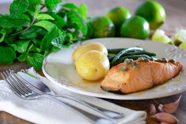 Güzel bir somon bifteği, kapari sosu, patates, sarımsak, maydanoz ve Fransız fasulyesi..