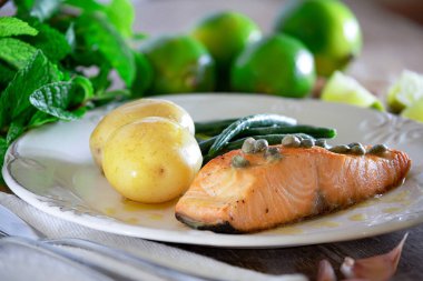 Güzel bir somon bifteği, kapari sosu, patates, sarımsak, maydanoz ve Fransız fasulyesi..
