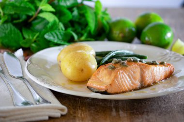 Güzel bir somon bifteği, kapari sosu, patates, sarımsak, maydanoz ve Fransız fasulyesi..