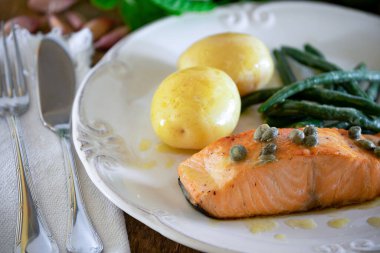 Güzel bir somon bifteği, kapari sosu, patates, sarımsak, maydanoz ve Fransız fasulyesi..