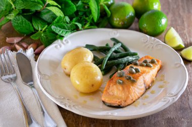 Güzel bir somon bifteği, kapari sosu, patates, sarımsak, maydanoz ve Fransız fasulyesi..