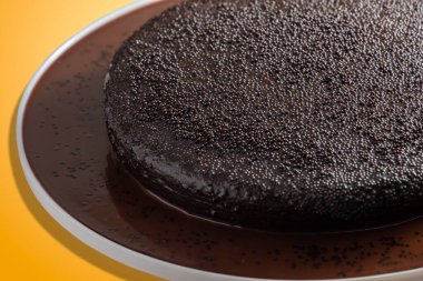 Koyu vejetaryen çikolatalı pasta, turuncu arka plan.