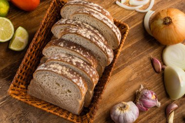 Tahta bir masada buğday unuyla dilimlenmiş beyaz ekmek..