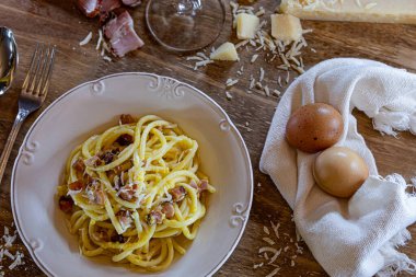 Carbonara makarna tabağı, tipik İtalyan tarifi parmesan peyniri, yumurta kremi ve pastırma. Seçici odaklanma. Üst görünüm.