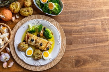 Zeytinyağında pişirilmiş morina filetosu, patates, brokoli, haşlanmış yumurta ve siyah zeytin. Tipik Portekiz yemeği. Üst Manzara. Metin için boşluk.