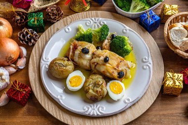 Zeytinyağında pişirilmiş morina filetosu, patates, brokoli, haşlanmış yumurta ve siyah zeytin. Tipik Portekiz yemeği. Noel süsü. Üst görünüm.