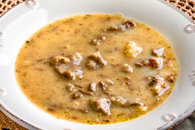 Tahta masada beyaz tabakta tatlı patates çorbası..