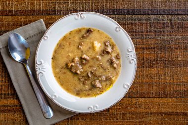 Tahta masada beyaz tabakta tatlı patates çorbası. Üst Manzara. Metin için boşluk.