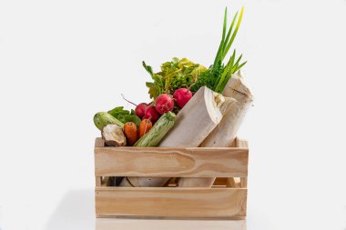 Tahta kutu, taze sebzeler ve beyaz arka planda organik yeşillikler. Biyolojik organik gıda. Detoks diyeti. Seçici odaklanma. Metin için boşluk.