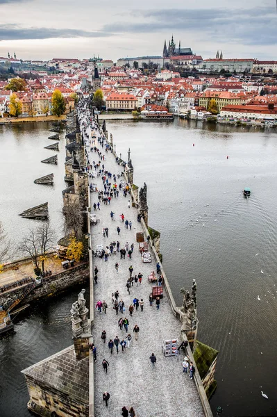 Prag Charles Köprüsü'ndeki turistler. Vltava nehri ile Prag. Kitle turizmi ile Cityscape — Stok fotoğraf