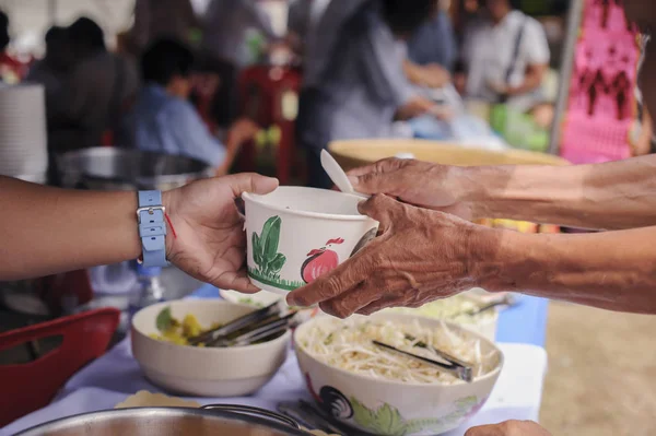 Social concept of poor people sharing : Concept serving free food to the poor : Free food, Using leftovers to feed the hungry : Food concept of hope : The poor are reaching for food