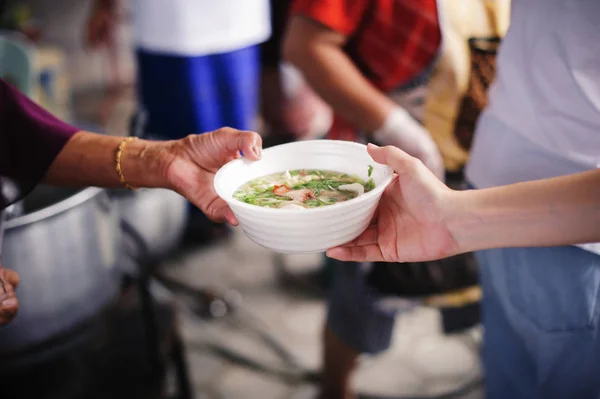 Food needs of the poor in society Help with Food Donation : Homeless people pick up charity food from the food donors in society : The concept of the beggar problem on earth