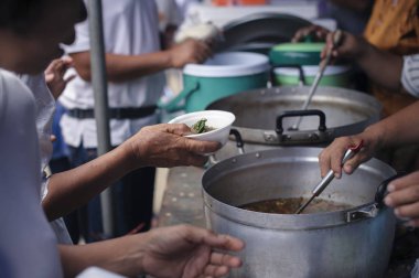 Mültecilerin ellerine açlığı hafifletmek için sadaka gıda ile desteklenmiştir : Beslenme Kavramları : El zengin bir adam dan gıda bağışlamak için sunulan Paylaş : Sosyal paylaşım kavramı