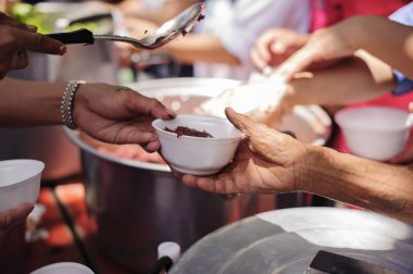 Mültecilerin ellerine açlığı hafifletmek için sadaka gıda ile desteklenmiştir : Beslenme Kavramları : El zengin bir adam dan gıda bağışlamak için sunulan Paylaş : Sosyal paylaşım kavramı