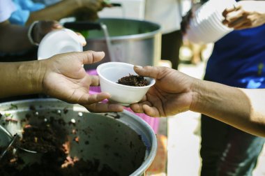 İnsancıllık kavramı : Mültecilerin ellerine açlığı hafifletmek için sadaka gıda ile desteklenmiştir : Beslenme Kavramları : Zengin bir adamdan yiyecek bağışlamayı teklif edilen el Paylaş