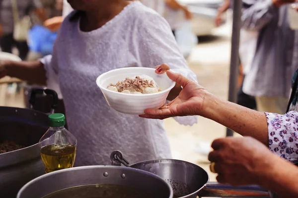 The Hand of the Beggars receives charity food from fellow human beings : The concept of humanitarianism : The hands of refugees have been aided by charity food to alleviate hunger : Feeding Concepts