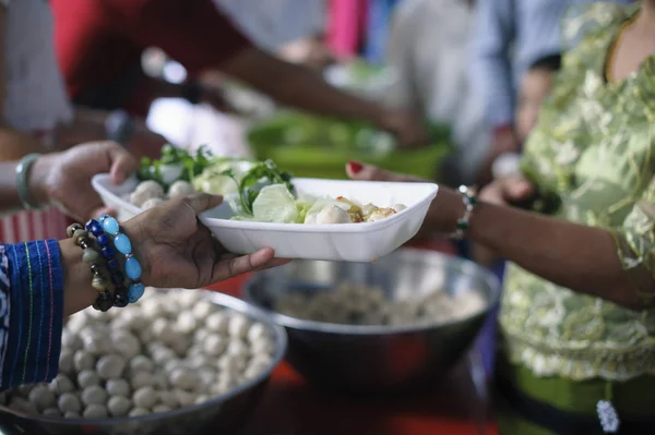 volunteers giving food to poor people in desperate need : The concept of food sharing Help solve Hunger for the homeless