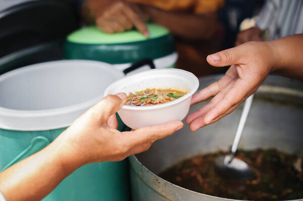 добровольцы, дающие пищу бедным людям в отчаянной нужде: Концепция обмена продуктами питания Помогает решить голод для бездомных
