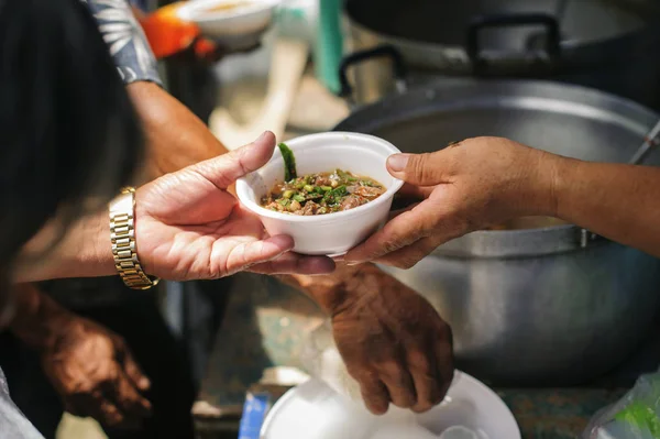 志愿者为贫困人群提供食物 食物共享的概念帮助解决无家可归者的饥饿问题 — 图库照片