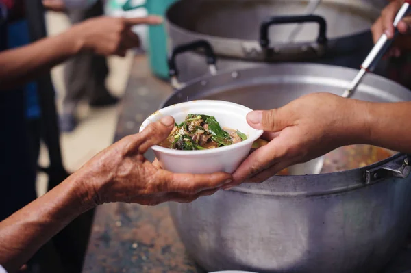 Homeless people are helped with food relief, famine relief : volunteers giving food to poor people in desperate need : The concept of food sharing Help solve Hunger for the homeless