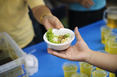Yoksullar için gıda paylaşımına katılım : Sevgi Kavramı : Dilenci hayır yardımlarından yiyecek bekliyor : Toplumdaki herkese paylaşılan sadaka gıdave yoksulların bu hayır yemeğine ihtiyacı var
