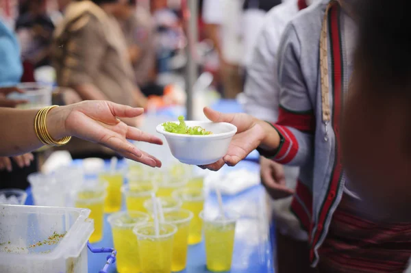 Hand begging for food from the rich\'s share : The beggar is waiting for food from charity aid : the concept of begging and hunger : Hunger problems of the poor have been donated food to reduce hunger